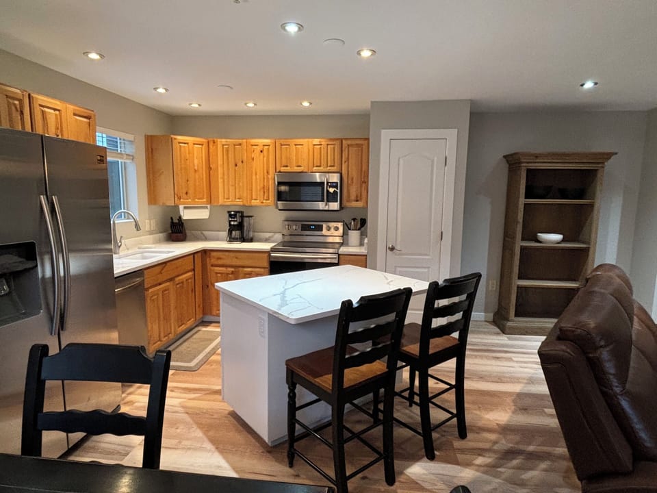 View of the fully equipped kitchen with quartz countertops and Island