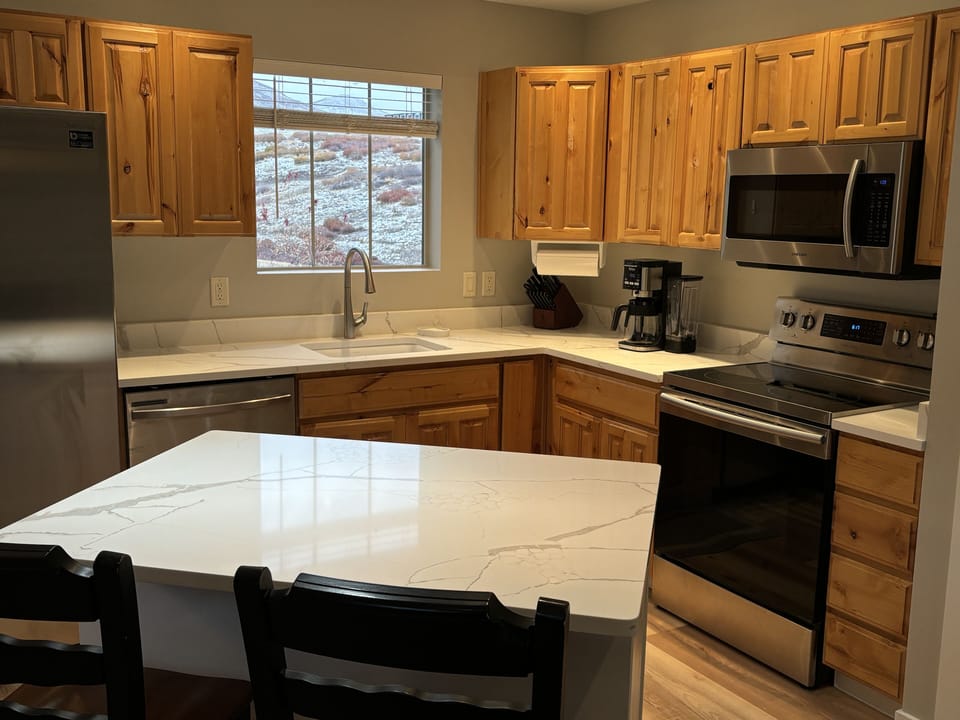 View of the fully equipped kitchen with quartz countertops and Island