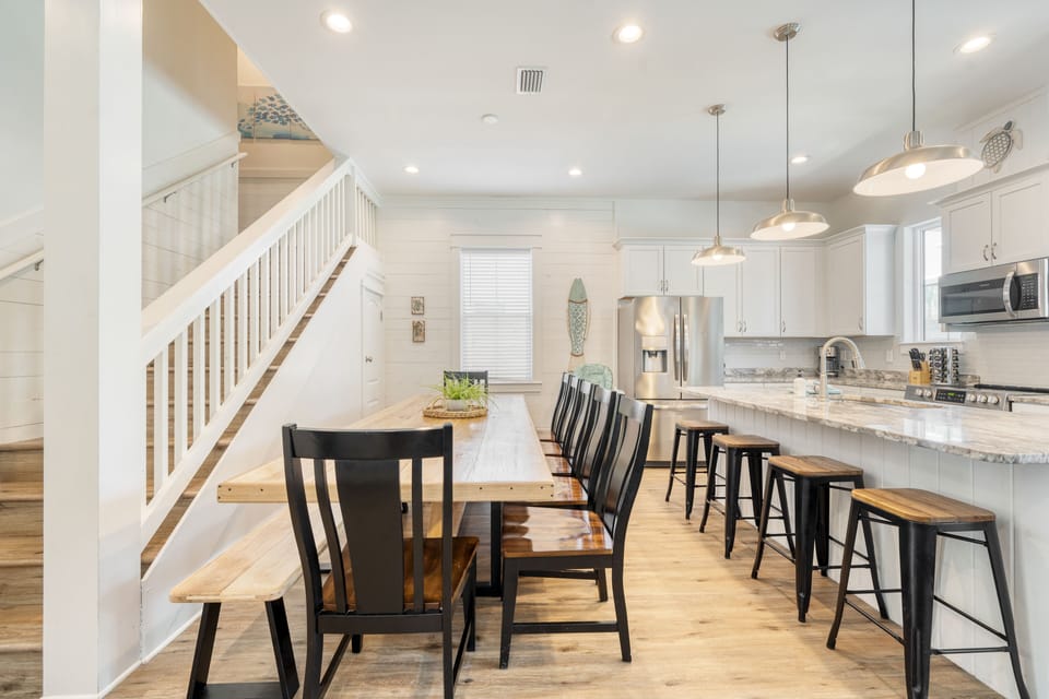 Spacious dining table with additional seating at the kitchen island.