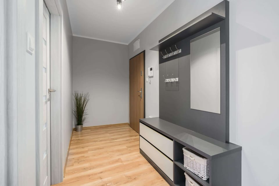 Hallway view featuring a sleek wardrobe, wooden flooring, and modern lighting.
