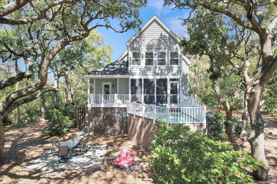 Charming beach house nestled under a canopy of oaks, featuring a private plunge pool, screened porch, and serene island setting
