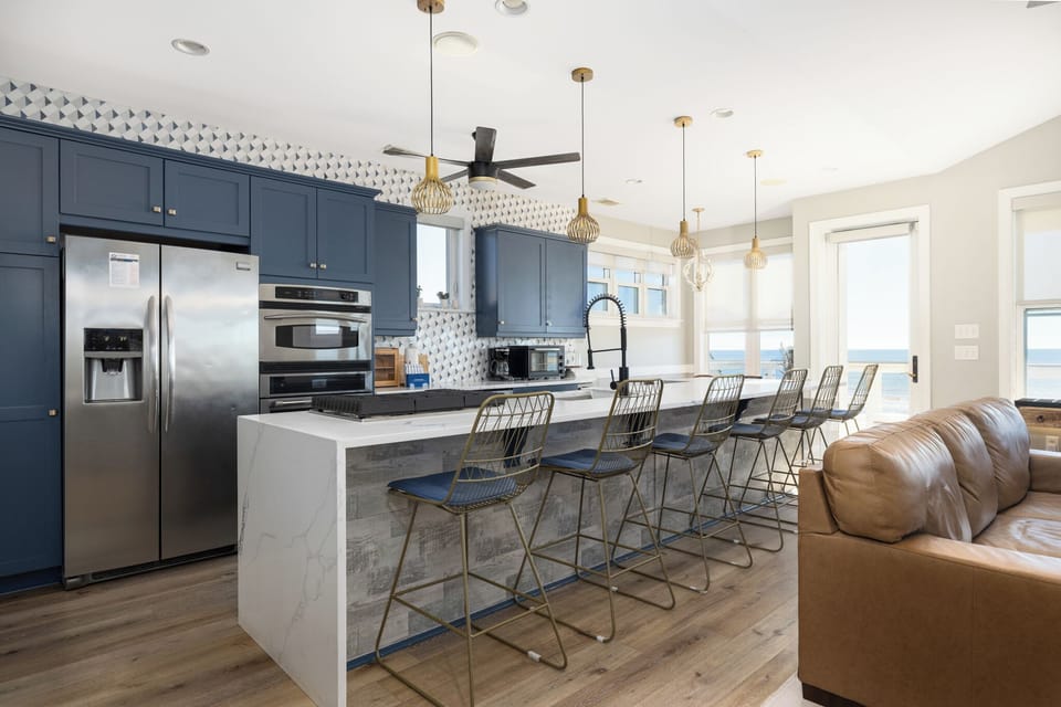 Your spacious open-concept kitchen welcomes you with sleek navy cabinetry and modern appliances