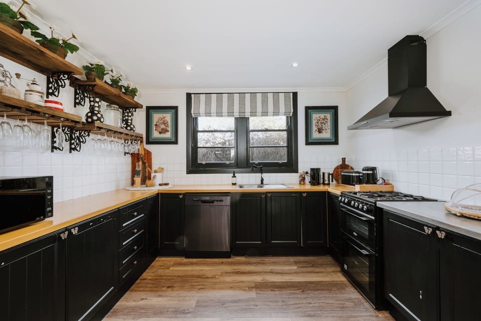 Cook with ease in the beautifully styled country kitchen, where open shelving, warm timber benchtops and quality appliances invite everything from leisurely breakfasts to shared dinners.