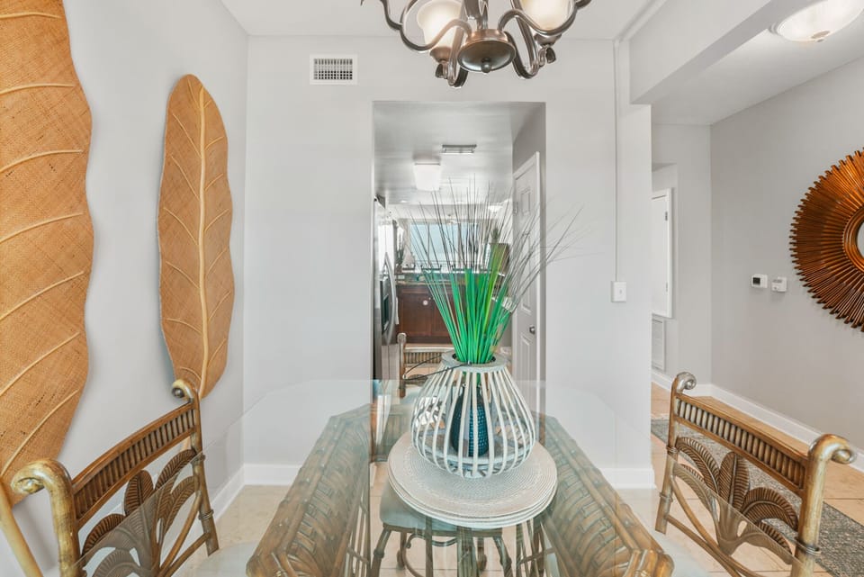 Your elegant dining space features coastal charm with wicker chairs and tropical décor, perfect for memorable meals together.