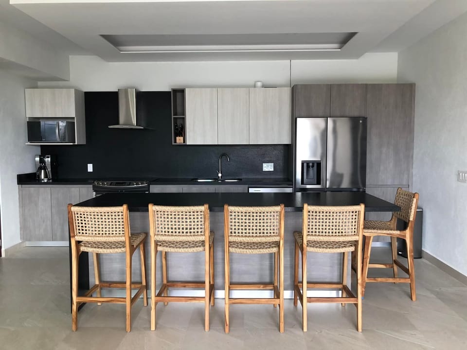 Large kitchen with numerous appliances, glassware and cooking necessities.