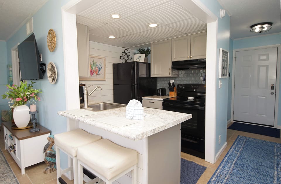 Your bright coastal kitchen features granite countertops, full appliances, and a convenient breakfast bar perfect for morning coffee or casual dining.