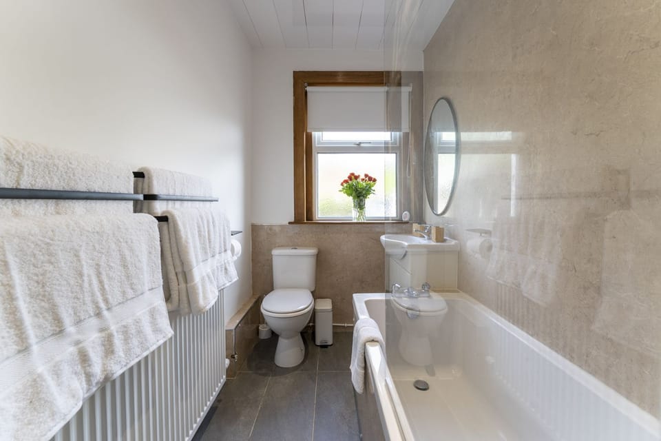 Modern bathroom with WC, sink and over bath shower
