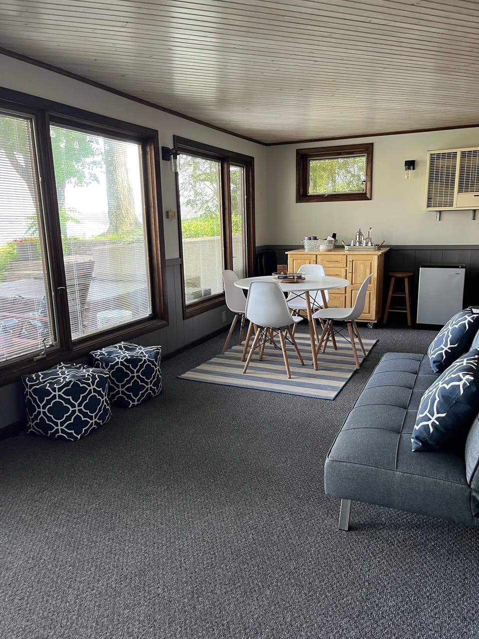 Downstairs three season room with futon couch and beverage fridge