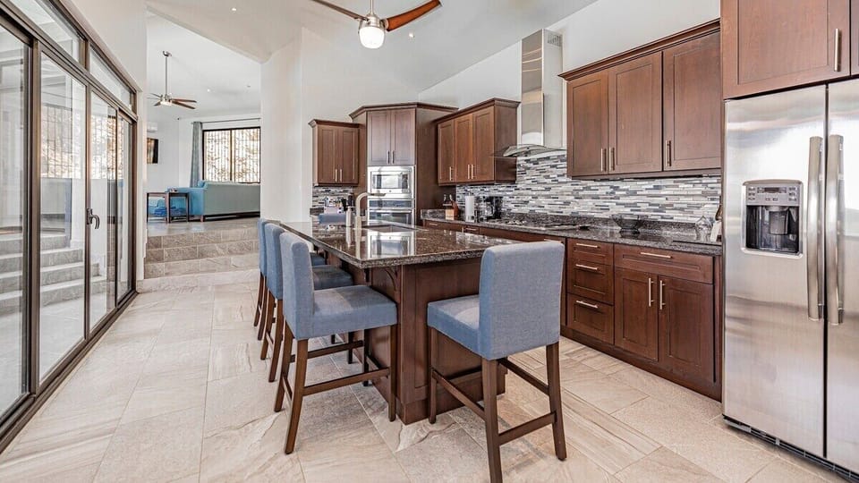 The large kitchen has a wall of windows & sliding doors that open to the pool deck.  