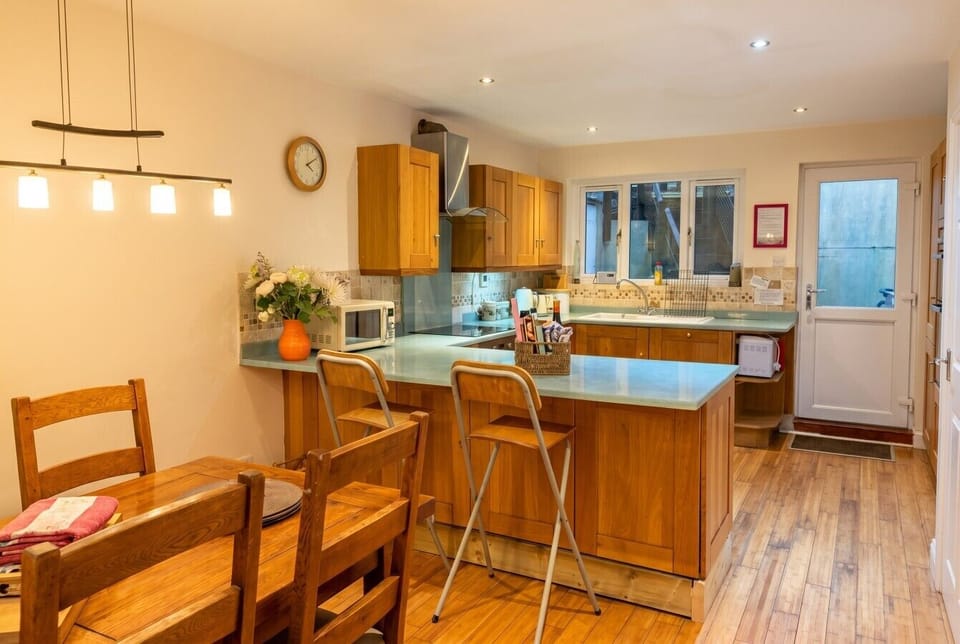 Bright open plan kitchen with bar stools and everything you need to cook.