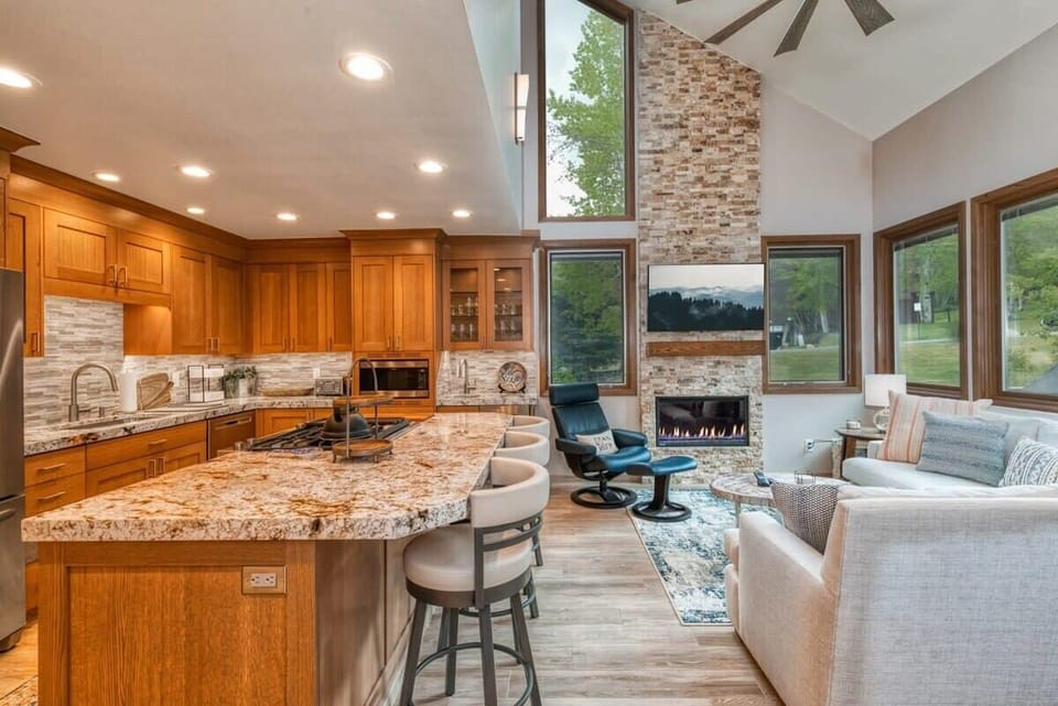 A spacious bar with seating for three serves as a beautiful bridge between the cozy living area and the fabulous, remodeled kitchen with its luxurious granite countertops, stainless steel appliances and tile backsplash.