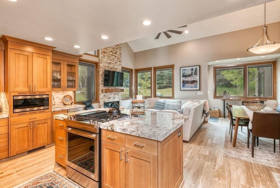 The view from the fully remodeled kitchen highlights its abundant counter space, roomy island with a gas range and bar seating for three and convenient proximity to the living and dining areas.