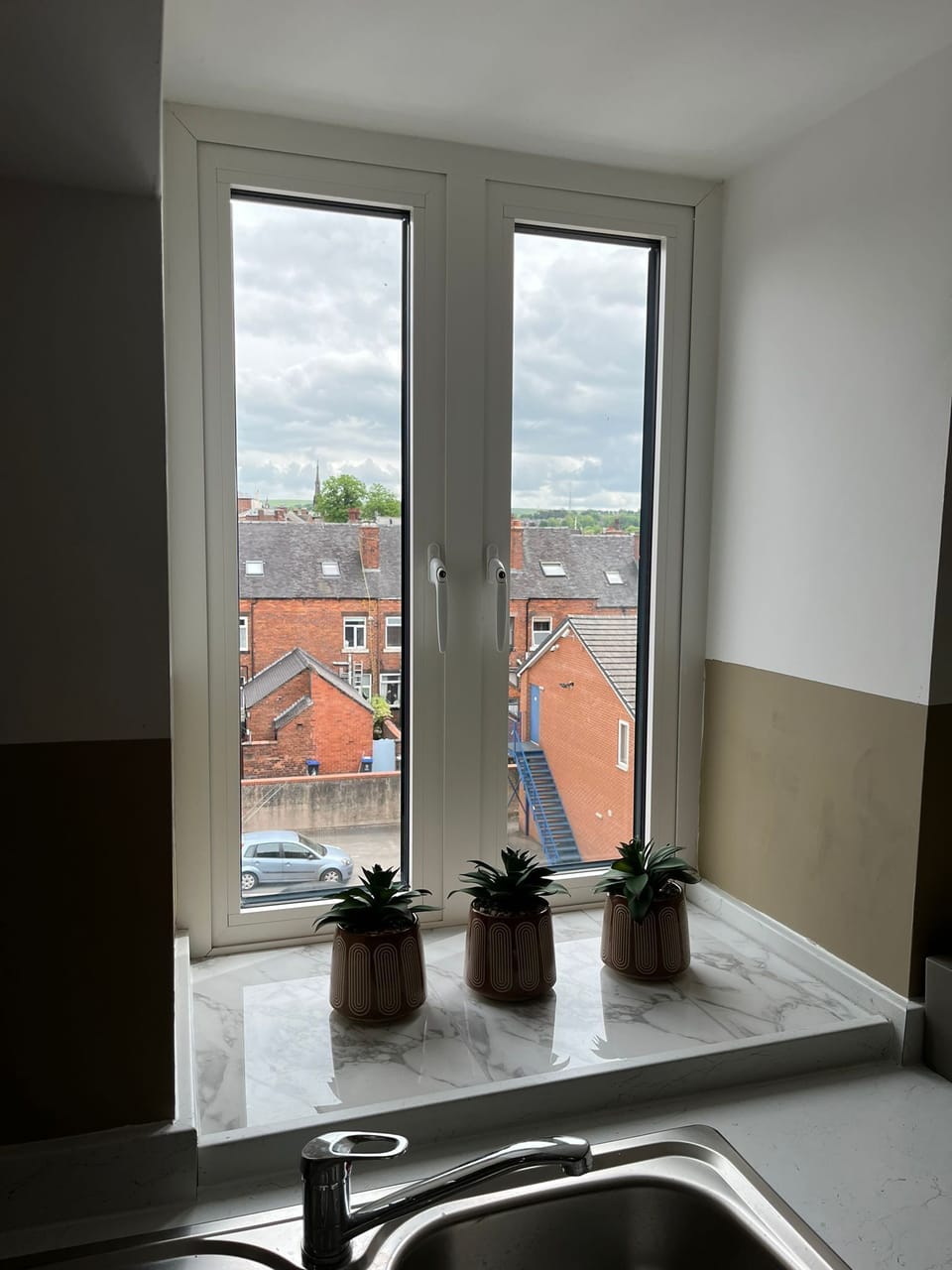 Top floor view over the rooftops to the hills