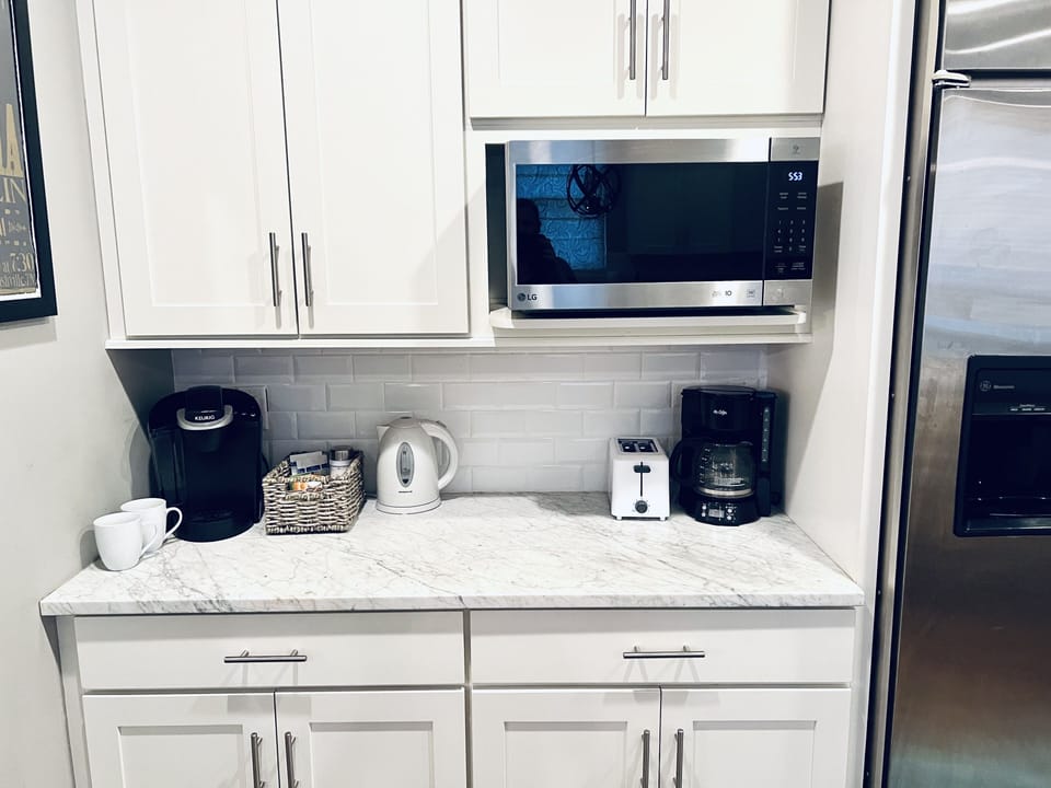 Coffee station with Keurig, regular pot coffee maker, and hot water kettle.