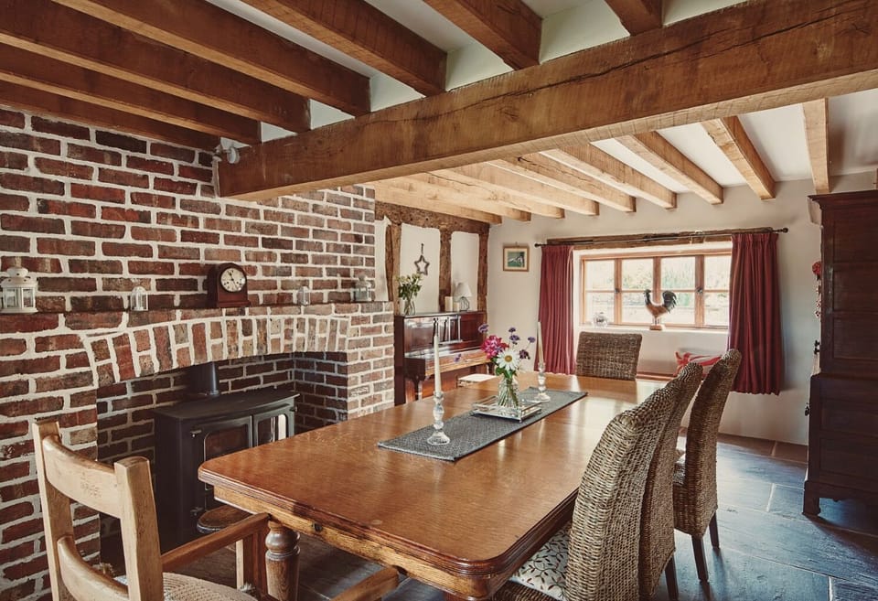 Traditional dining room with statement brick fireplace, games cupboard and piano