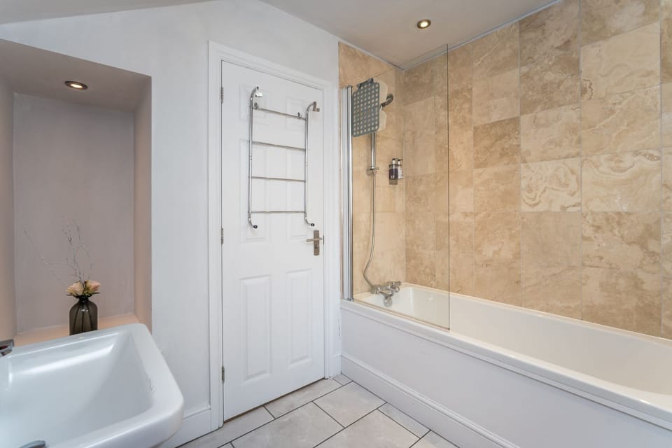 The family bathroom comprises bath with overhead shower, WC and hand basin, Complimentary Cole and Lewis toiletries are included