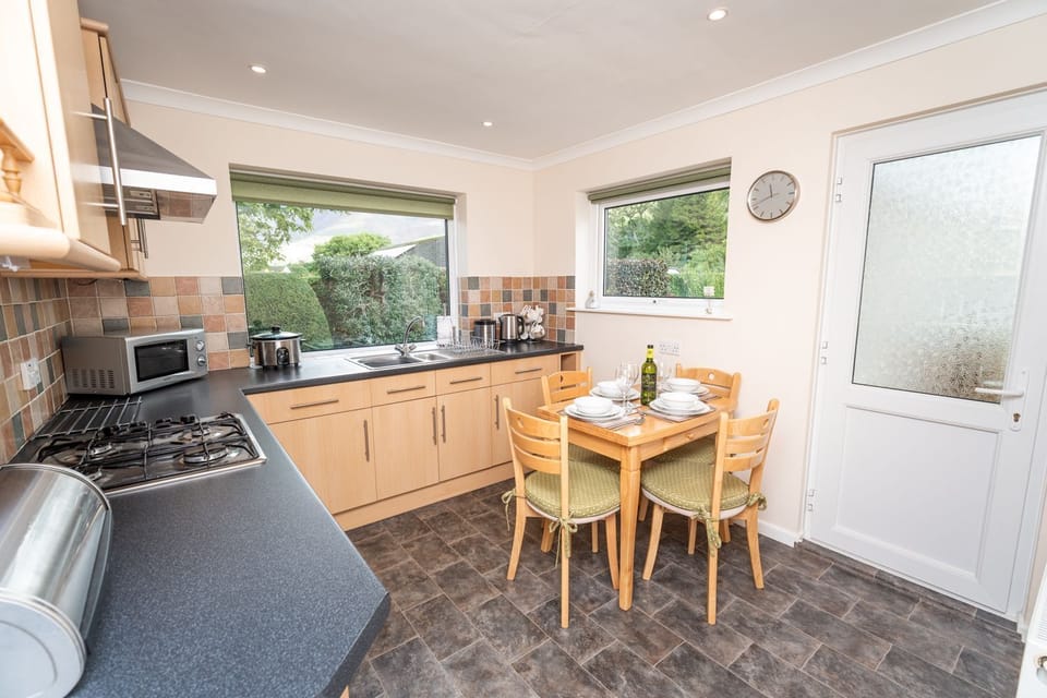 The modern family bathroom comprises bath with overhead shower, WC, hand basin and heated towel rail