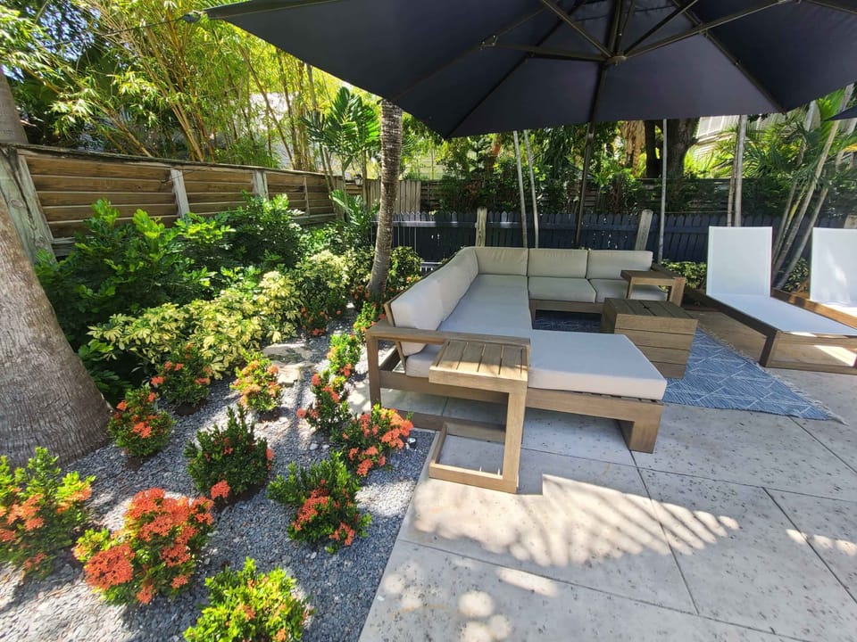 Chaise lounge sofa with umbrella and reclining sun chairs swimming pool view