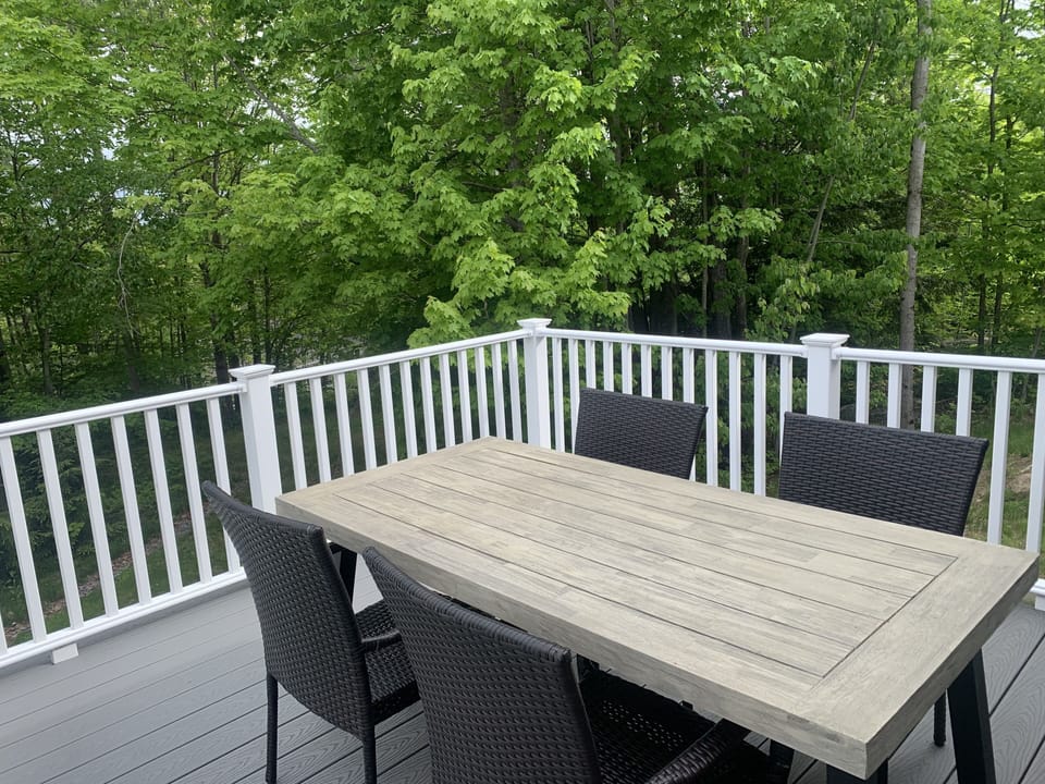 Back deck with table, chairs, and a bench. Wonderful for morning coffee/meals