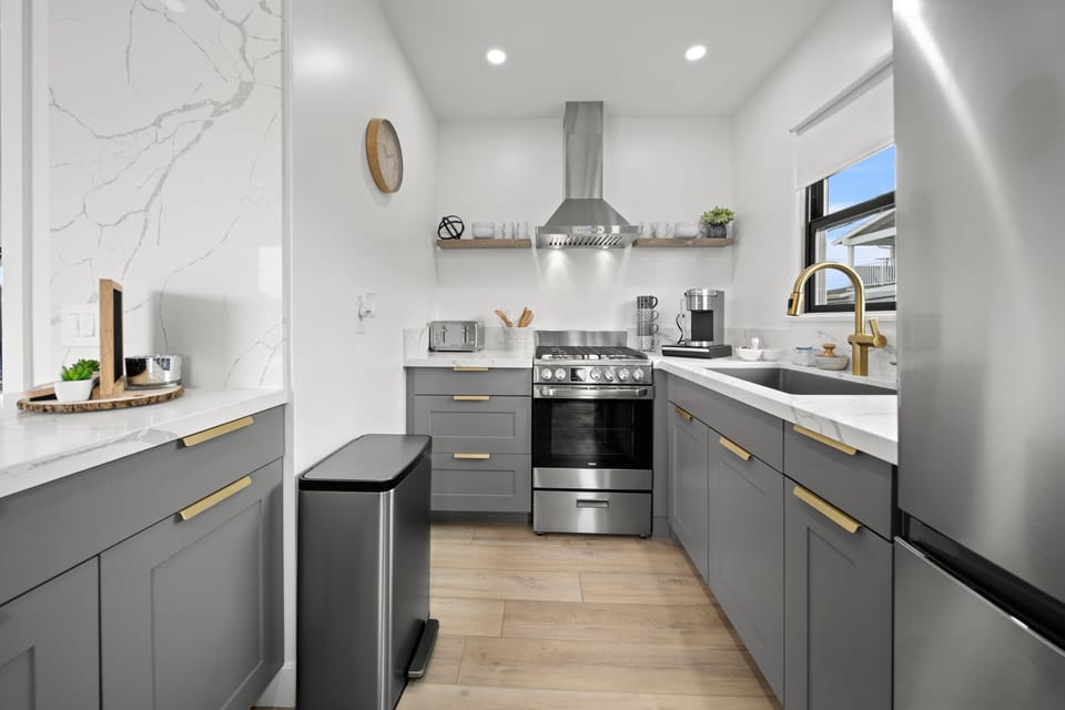 Fully stocked kitchen with coffee maker, toaster and dishes. pots and pans