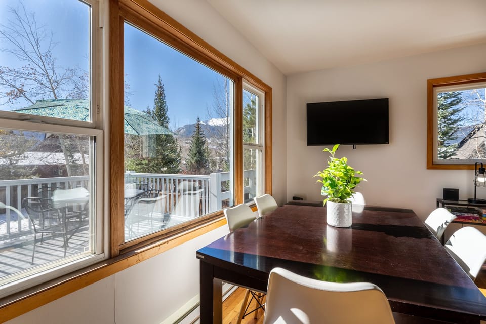 Dining area offering seating for six and mountain views from the surrounding windows.