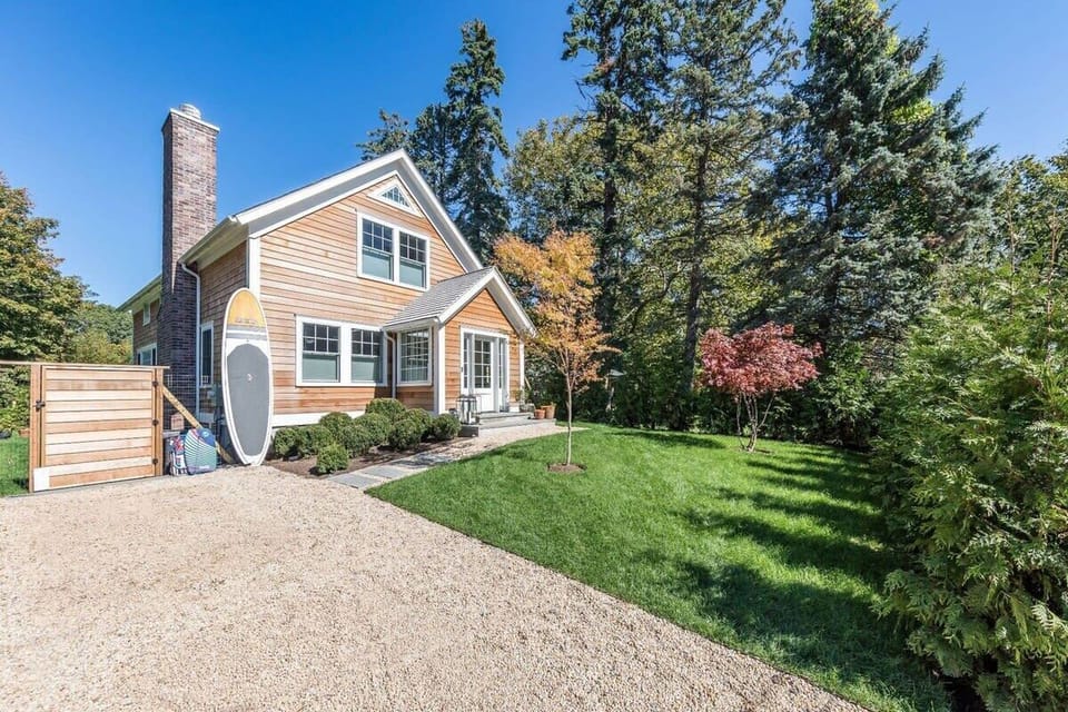 Home Façade and entrance surrounded by grass and big trees