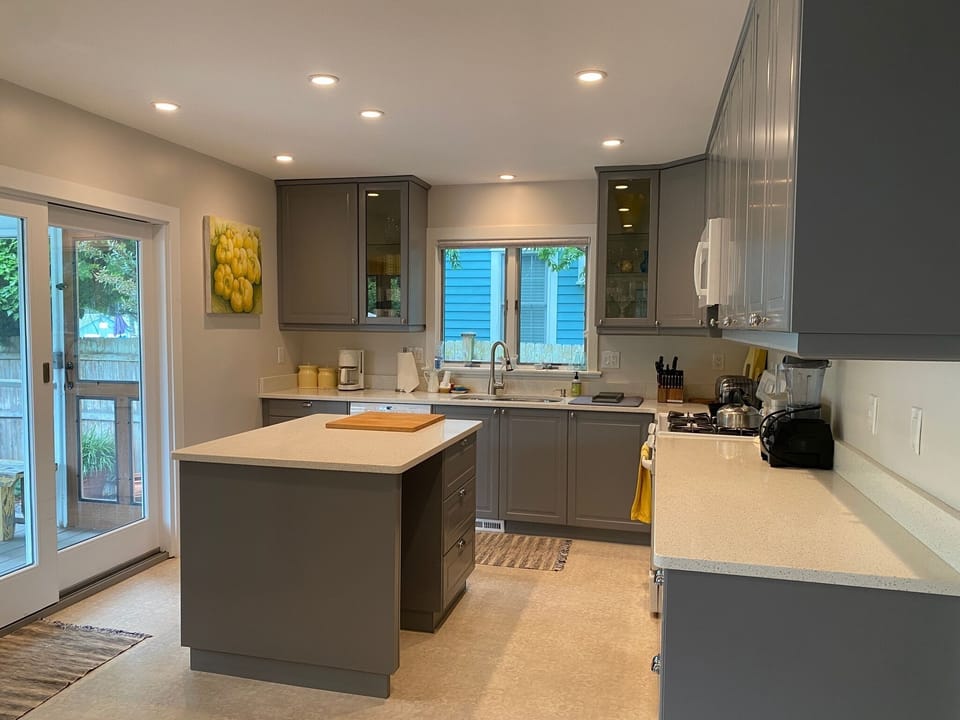 Modern kitchen showing sliding glass door leading to screened porch