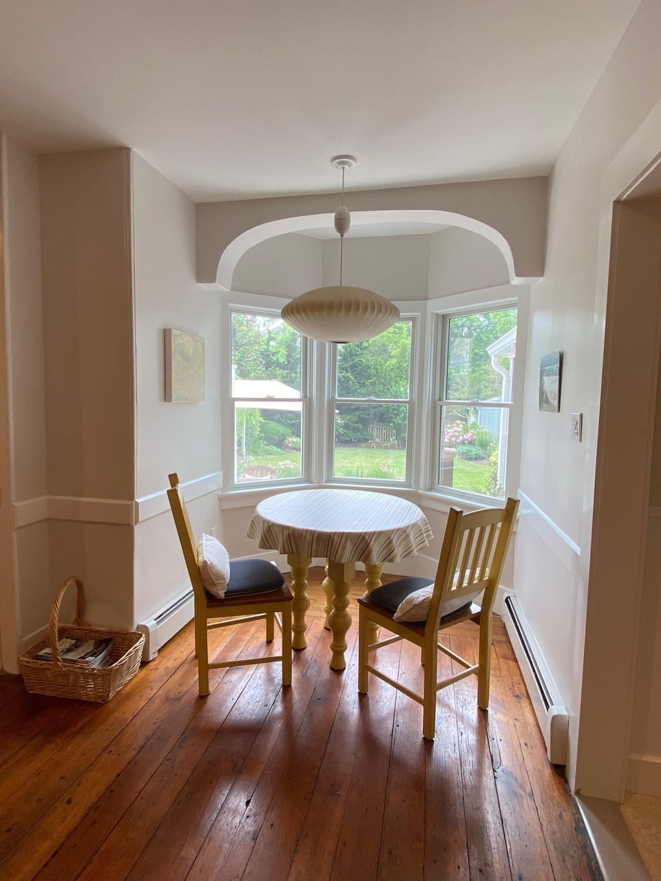 Additional dining table in dining room alcove overlooking rear lawn and gardens.