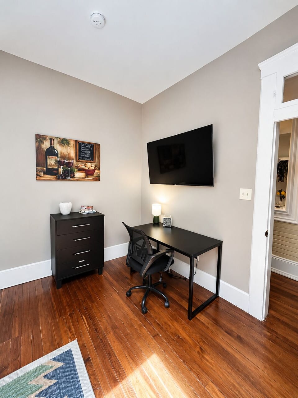 The bathroom provides a dark double-sink vanity, a large framed mirror, and a glass shower.