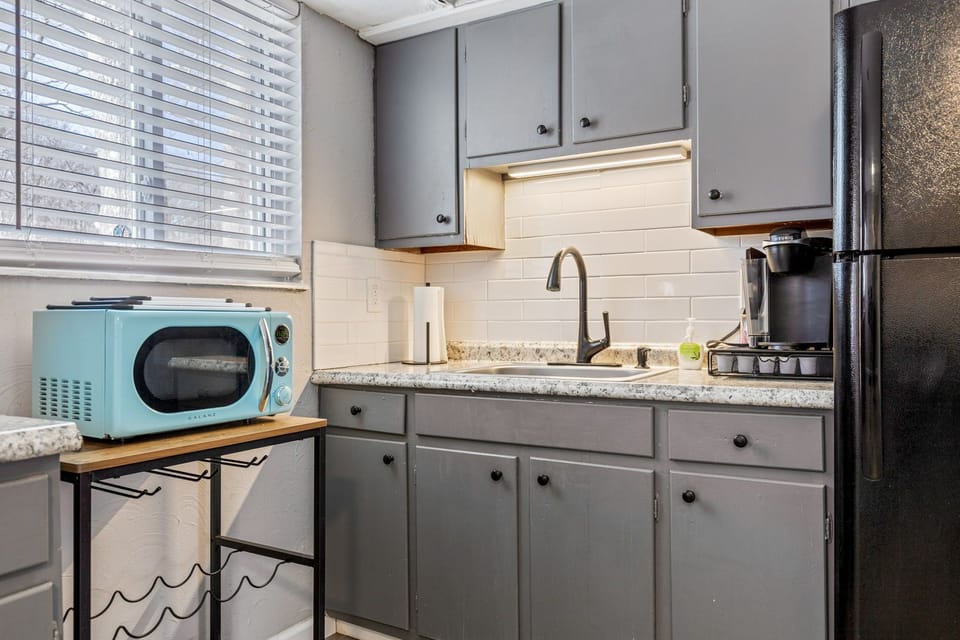 The kitchen counter includes the sink, microwave, and a single-serve coffee maker.