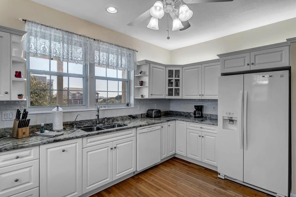 - Full size fridge, coffee maker, toaster, and extra cabinets make this kitchen as practical as it is pretty
- Plenty of space for storing groceries and prepping beach snacks
- Clean lines and a bright color palette keep it cheerful and coastal