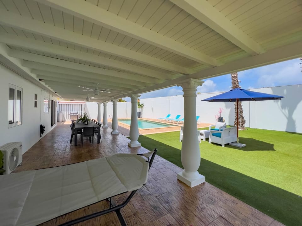 Outdoor patio with large dining space and comfortable hammock.