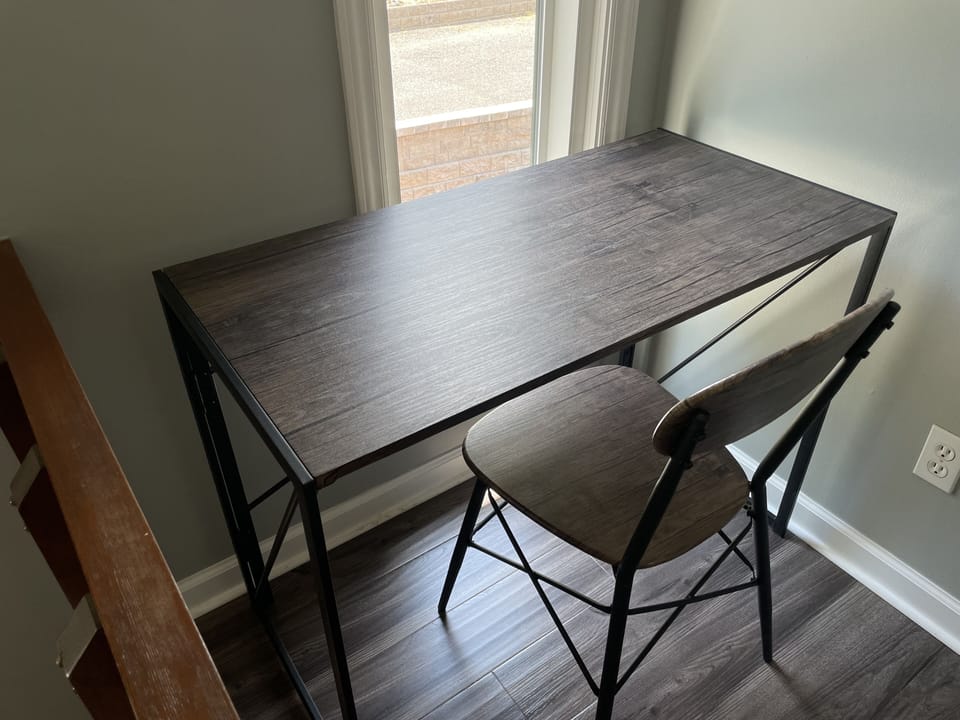 Dedicated workspace located at top of stairs landing adjacent to guest suite