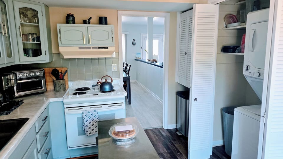 Washer/dryer in closet off kitchen; room adjoins dining room and back door area.