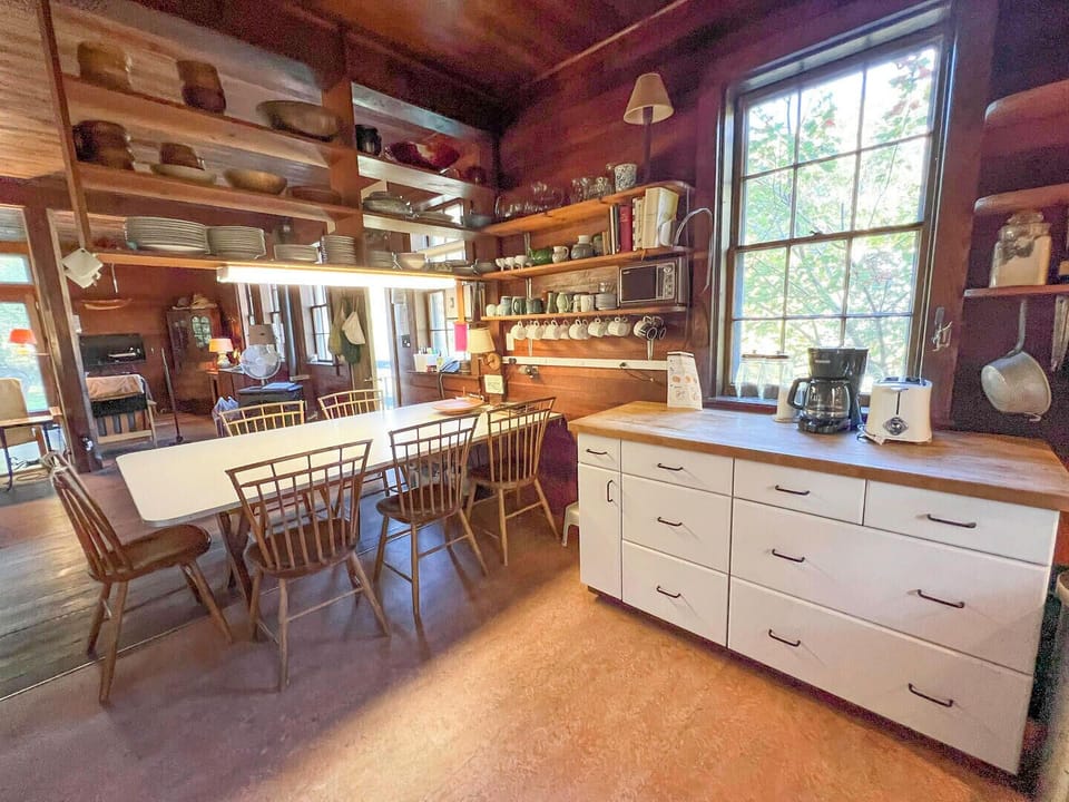 dining table with coffee station overlooking woods