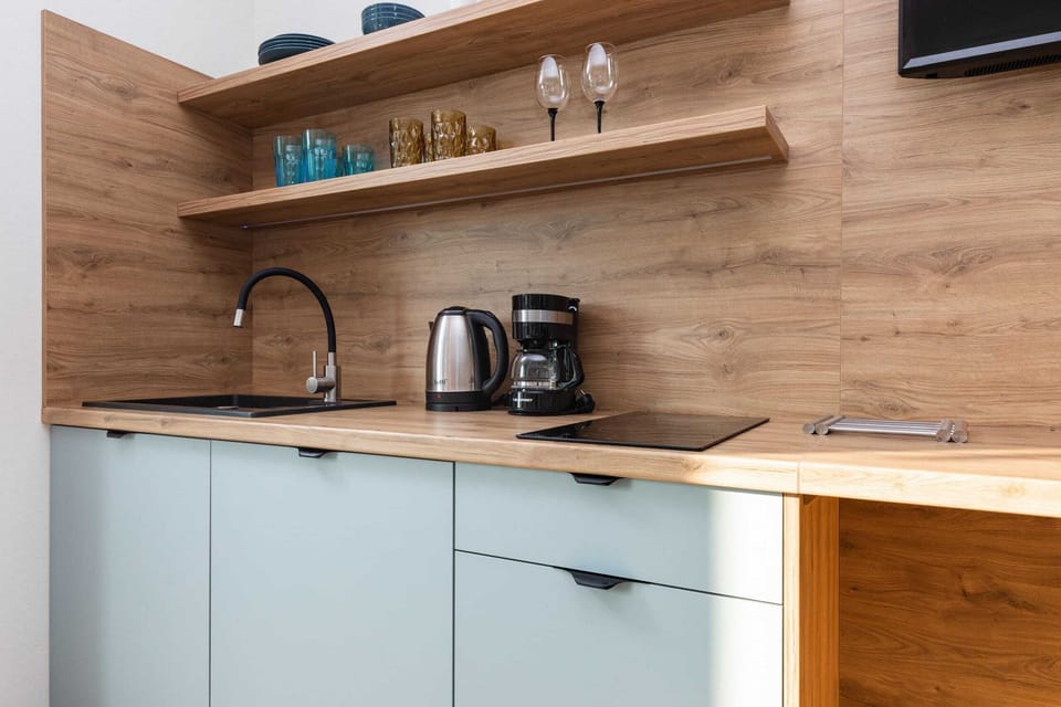 Kitchenette with plenty of kitchen utensils and dishes. 