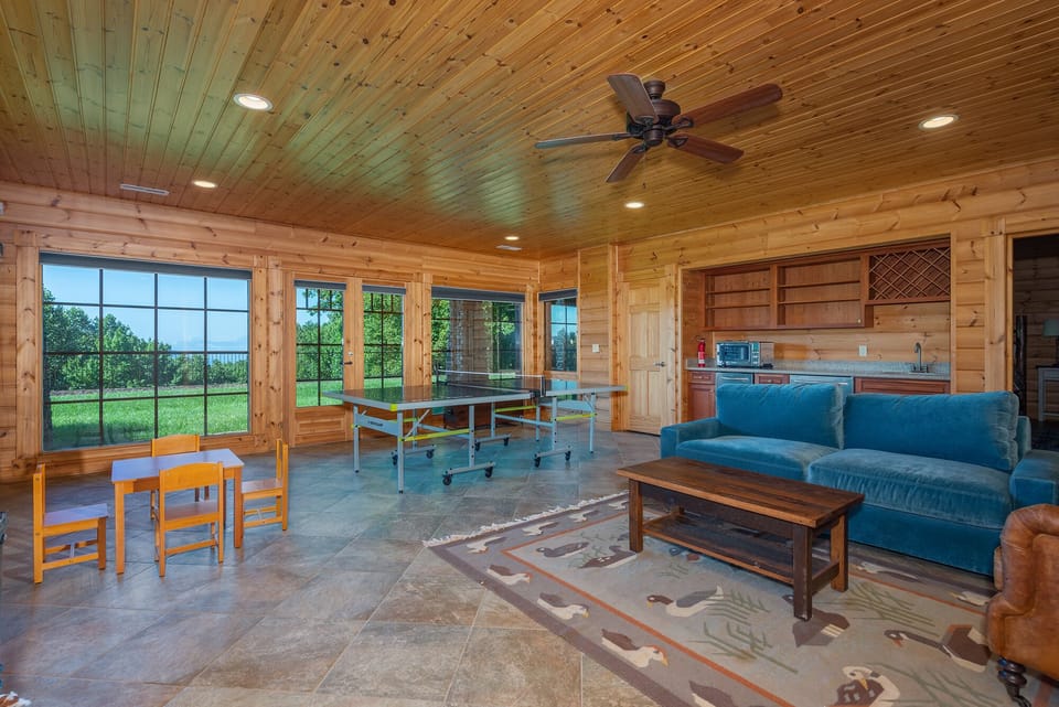 Lower-level den with ping pong table, bar area, and TV for streaming.