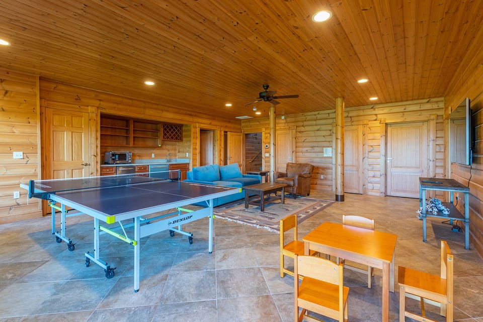 Lower-level den with ping pong table, bar area, and TV for streaming.