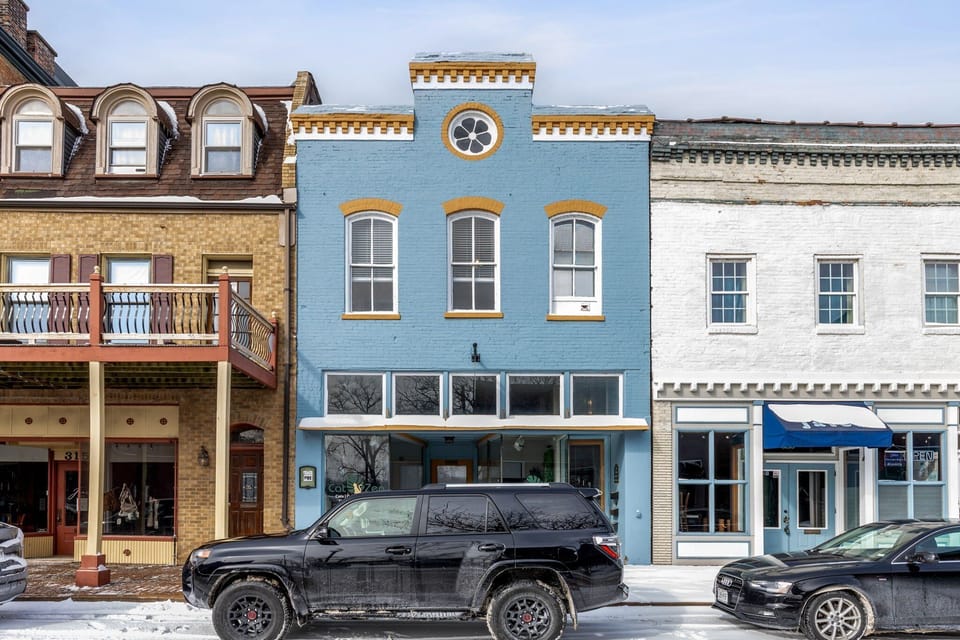 The studio is located in the blue historic building along Main Street.