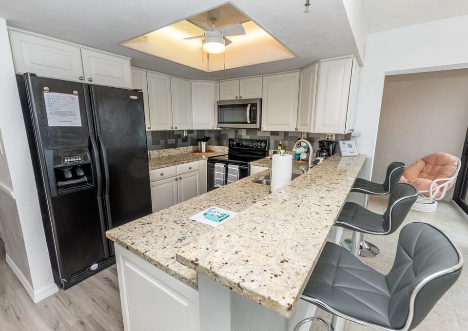 Kitchen with Toaster, Coffee Maker, Dishes, Cookware, Utensils.