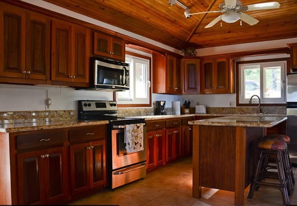 The kitchen has stainless appliances, Honduran cabinets, granite, island.