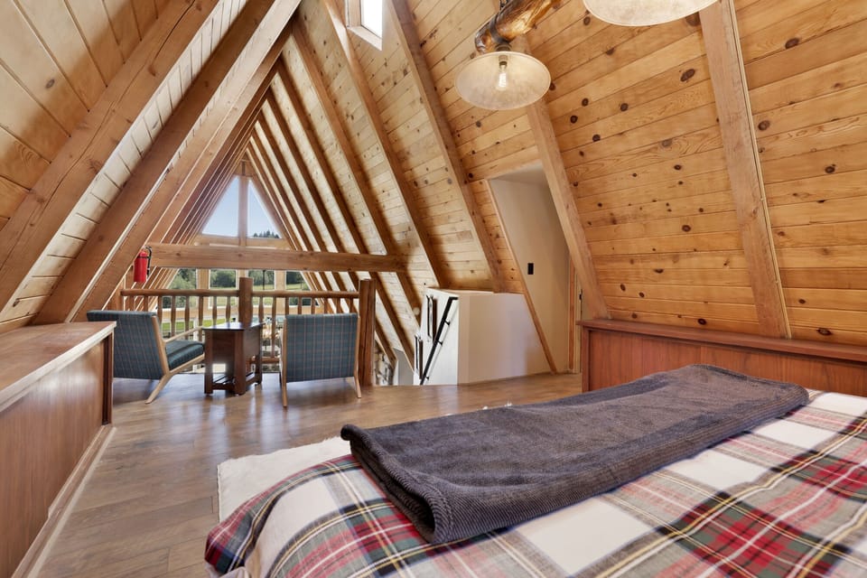 Peaceful cabin bedroom with plush bedding, and beautiful views—ideal for restful nights, cozy mornings, and a relaxing mountain escape.