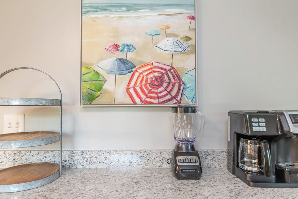 Start your mornings at the cozy coffee nook tucked along the kitchen counter—an inviting spot where the aroma of fresh brew mingles with sea-salt