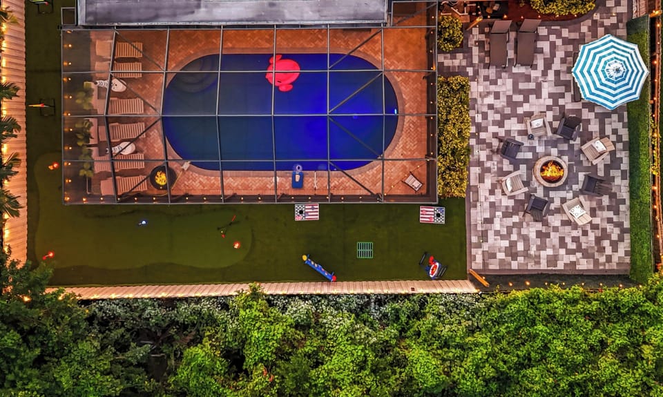 Kids having a blast playing cornhole, axe throwing and putt putt while the adults relax and watch a movie from outdoor theater from the cozy seating area — surrounded by nature's beauty and a