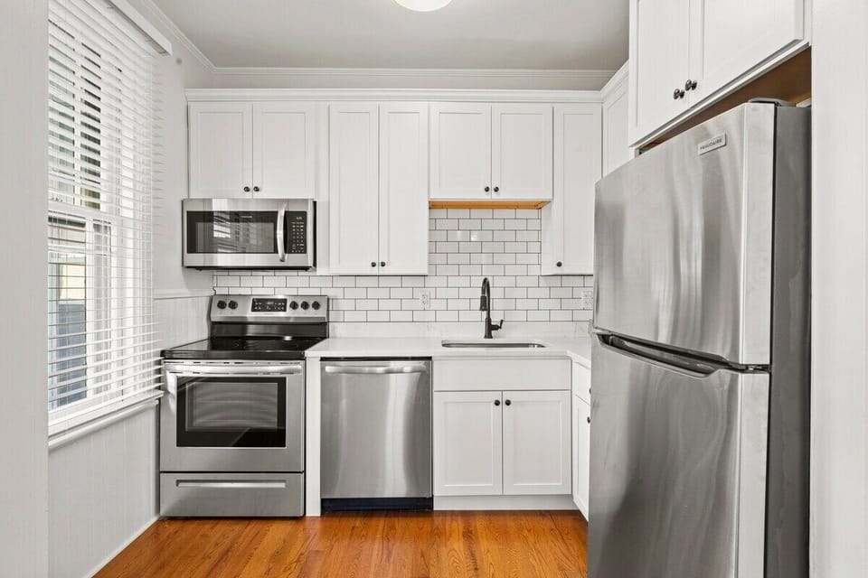 Full kitchen equipped with full size Stainless Steel appliances, Quartz counter tops, Luxe faucet, inset sink and clean crisp white Subway tile