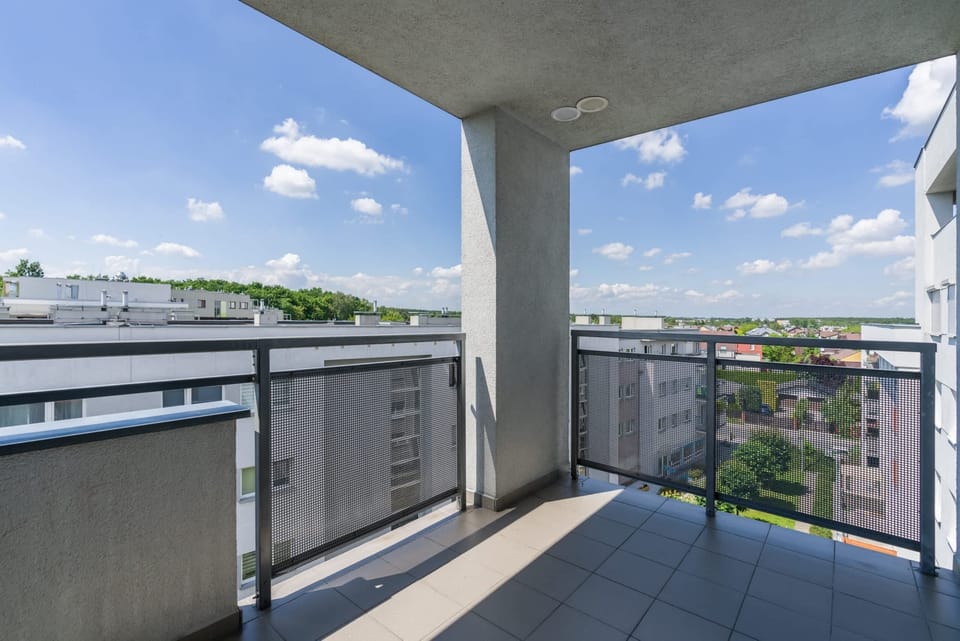 Spacious balcony with outdoor furniture. 