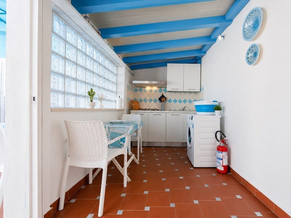 Bright blue-and-white kitchenette with dining nook and coastal charm