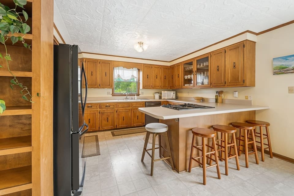 Full size kitchen featuring tons of countertop space, barstool seating, and a modern dining set for six.