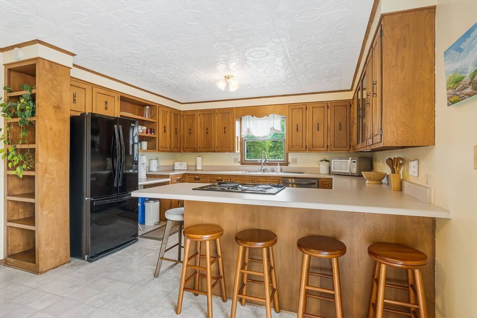 Full size kitchen featuring tons of countertop space, barstool seating, and a modern dining set for six.