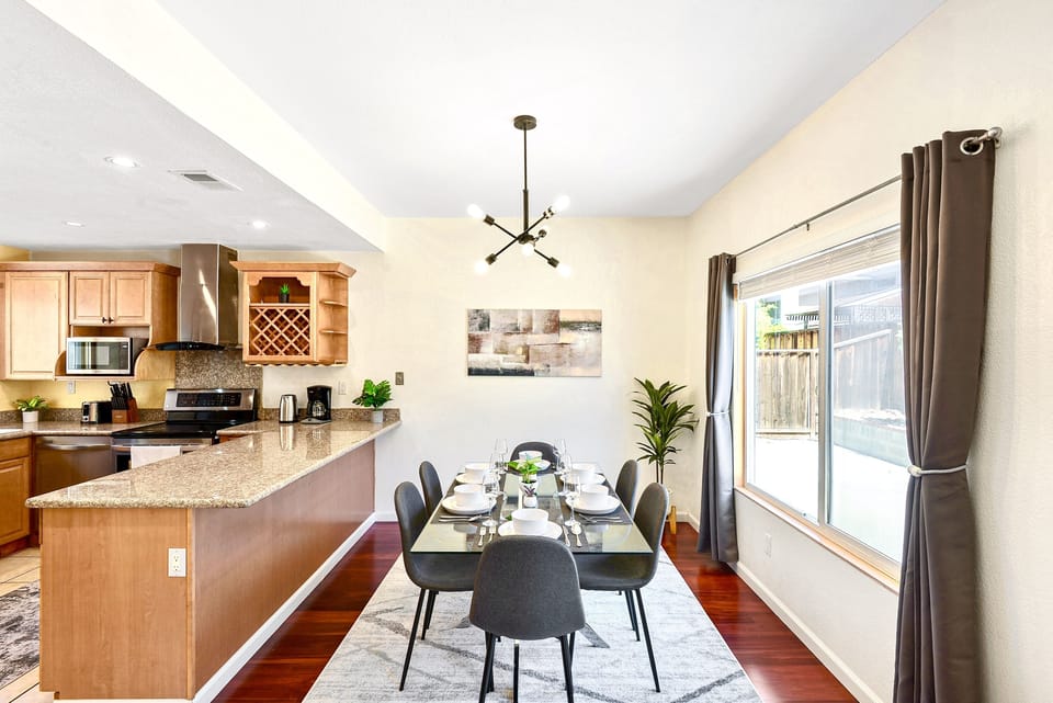 Dining area. Modern glass table and Sputnik chandelier. Lots of natural light